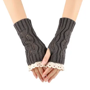 Detailed close-up of grey knit fingerless gloves with hollow leaf pattern and white lace trim.