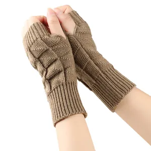 Detail view of brown knitted fingerless gloves for women with thick textured patterns.