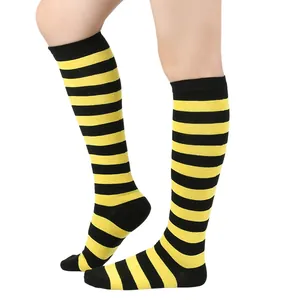 Vue latérale de chaussettes montantes à rayures jaunes et noires sur un mannequin