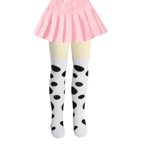 Detailed view of girls' white over-the-knee socks with bold black polka dots pattern