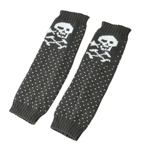 Detailed view of dark grey knitted leg warmers with white skull and polka dot patterns