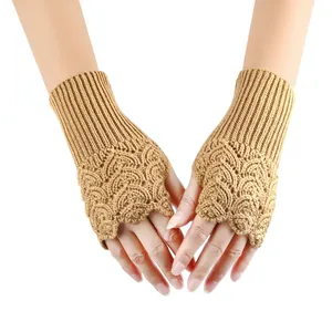 Close-up of camel knitted fingerless gloves with an intricate heart-shaped open-work pattern.