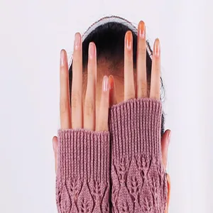 Close-up view of mauve knitted fingerless gloves with hollow leaf pattern