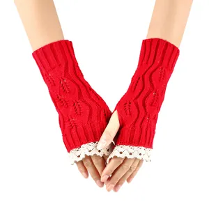 Close-up of red knitted fingerless gloves with white lace trim and leaf cutout design