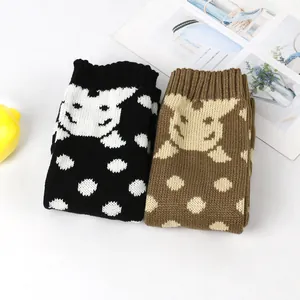 Detailweergave van schattige gebreide cartoon hondenbeenwarmers met stippen.
