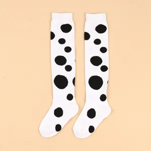 Detailed view of white over-the-knee children's socks with large black polka dots