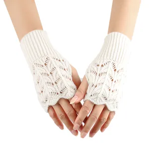 Detailed view of white knitted fingerless gloves featuring elegant hollow heart patterns