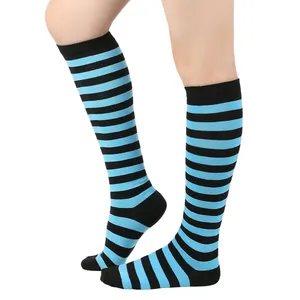 Gros plan montrant le motif rayé bleu et noir vif de ces chaussettes montantes au genou.