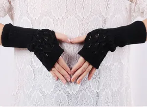 Detailed view of black hollow knit fingerless long arm warmers showing delicate pattern
