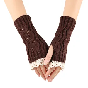 Detailed close-up of brown knitted fingerless gloves with white lace trim and leaf pattern