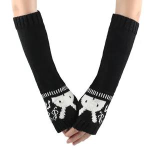 Detail van zwarte gebreide lange vingerloze armwarmers met schattig wit konijnenpatroon