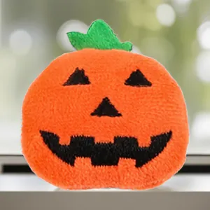 Detailed view of an orange plush pumpkin accessory with embroidered face for Halloween DIY decor.