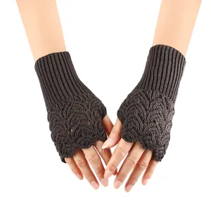 Close-up of brown knitted fingerless gloves featuring a delicate hollow heart pattern