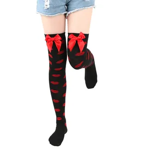 Close-up detail view of black thigh-high socks featuring red lip patterns and satin bows