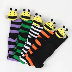 Close-up view of cute children bee long socks featuring colorful stripes and plush dolls