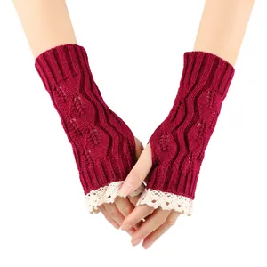 Close-up detail of wine red knitted fingerless gloves featuring delicate white lace trim