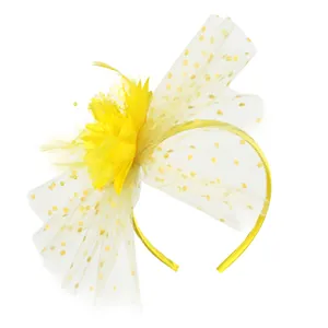 Detailed view of yellow vintage fascinator headband with polka dot mesh veil and feathers