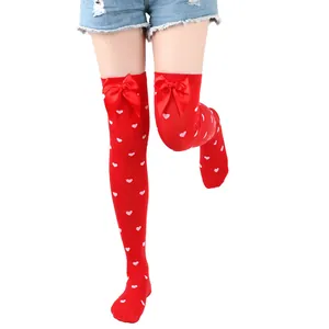 Detailed view of red over-the-knee socks featuring heart patterns and cute satin bows