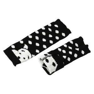 Detailweergave van gebreide beenwarmers met hondenmotief, stippen en ribboorden.