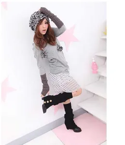 Close-up detail of Japanese style black knit leg warmers with side button decor on model