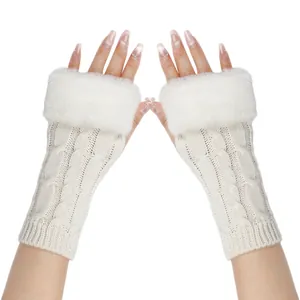 Close-up of cable knit fingerless gloves with white faux fur trim for winter warmth.