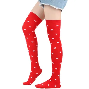 Detail view of red over-the-knee socks with pink heart pattern for Valentine's Day