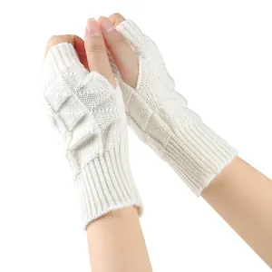 Detail view of white knitted fingerless gloves showing thick cable knit texture
