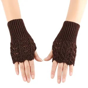 Detail shot of brown knitted fingerless gloves featuring an intricate heart hollow pattern