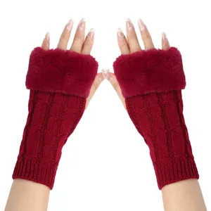 Detail of red cable knit fingerless gloves with plush faux fur cuff for winter warmth.