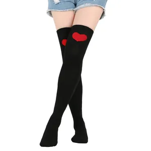 Close-up of black over-the-knee socks featuring a red heart pattern on the top cuff.