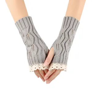 Close-up of grey knitted fingerless gloves with delicate white lace trim and leaf pattern.