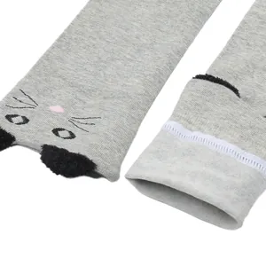 Close-up detail of grey over-the-knee socks with cute cartoon cat face and plush ears