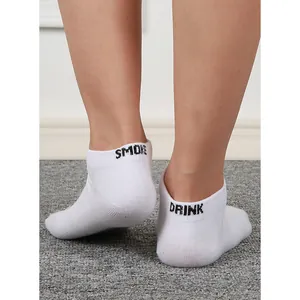 Detailed close-up of white funny letter ankle socks featuring SMOKE and DRINK text design