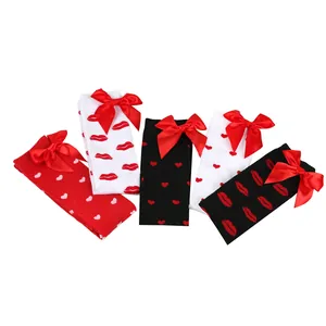 Detail showing red lip and heart patterns on over-the-knee socks with satin bows