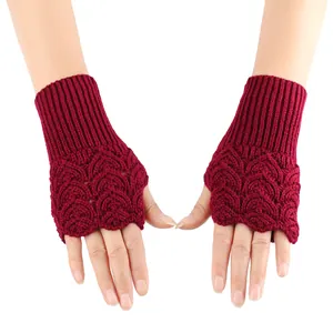 Detailed view of dark red knitted fingerless gloves with heart-shaped hollow-out patterns