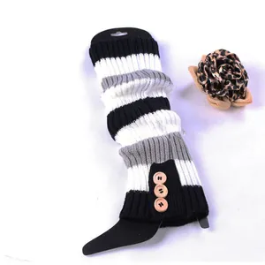 Detailed close-up view of black and white striped knitted leg warmers with three wood buttons