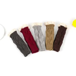 Assorted colors of knitted wrist warmers with lace trim and hollow leaf patterns.