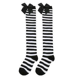 Detalle de los calcetines por encima de la rodilla a rayas blancas y negras con lazos negros