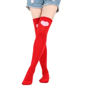 Close-up of red over-the-knee socks with pink heart pattern for Valentine's Day