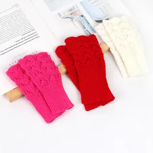 Macro view of heart-shaped openwork pattern on colorful knitted fingerless gloves.