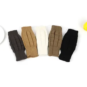 Detailed view of textured knitted fingerless arm warmers in various neutral colors