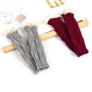Detailed view of knitted arm warmers featuring a leaf pattern and delicate lace trim