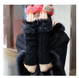Close-up of black cable knit fingerless arm warmers with thick plush faux fur trim
