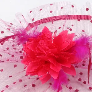 Detailed macro view of a pink fascinator headband featuring fabric flower and mesh veil