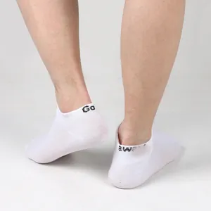 Macro detail of white men's cotton low cut ankle socks with 'Go away' knitted text.
