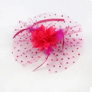 Detail of fuchsia fascinator with mesh veil, feathers, and a large fabric flower