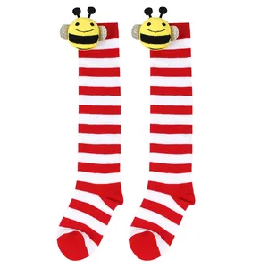 Detailed view of children's red and white striped knee-high socks with cute bee doll