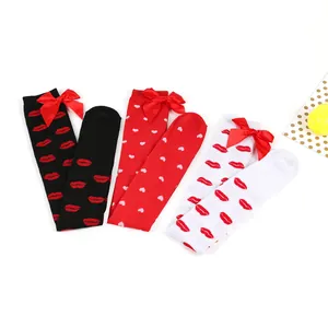 Close-up detail of three pairs of over-the-knee socks with heart and lip patterns and bows