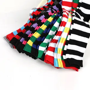 Vue détaillée de diverses chaussettes hautes rayées colorées empilées.