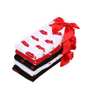 Stack of over-the-knee socks with red lip and heart patterns and satin bows